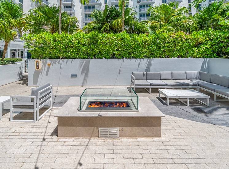 A patio with a fire pit and seating area.